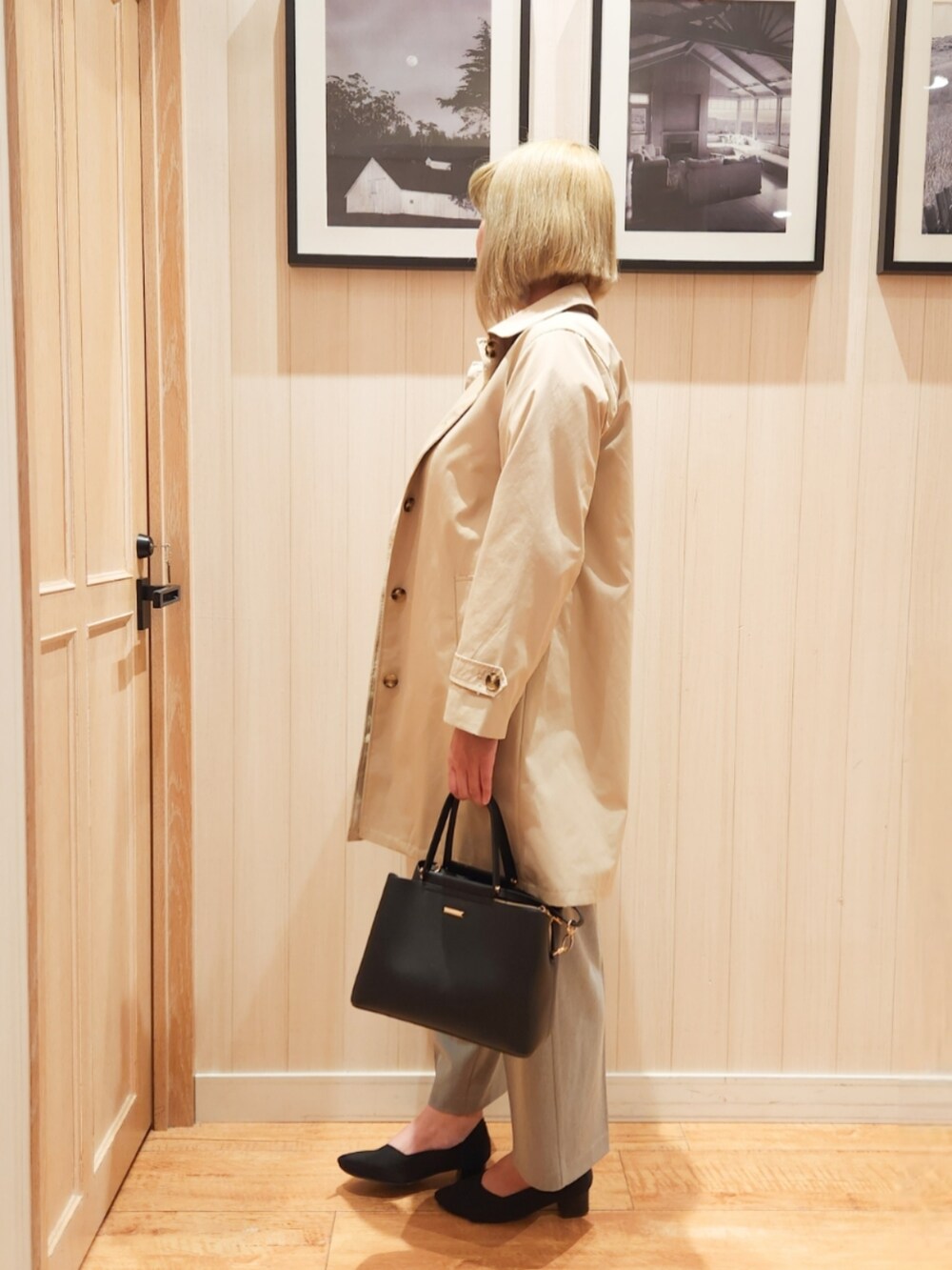 ブルー系のニット/セーター、ベージュ系のステンカラーコート、グレー系のその他パンツを着用したレディースの春コーディネートの2枚目の写真