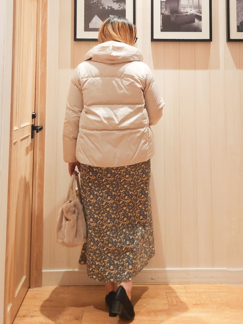 ベージュ系のダウンジャケット/コート、ベージュ系のニット/セーター、ブルー系のスカートを着用したレディースの冬コーディネートの3枚目の写真