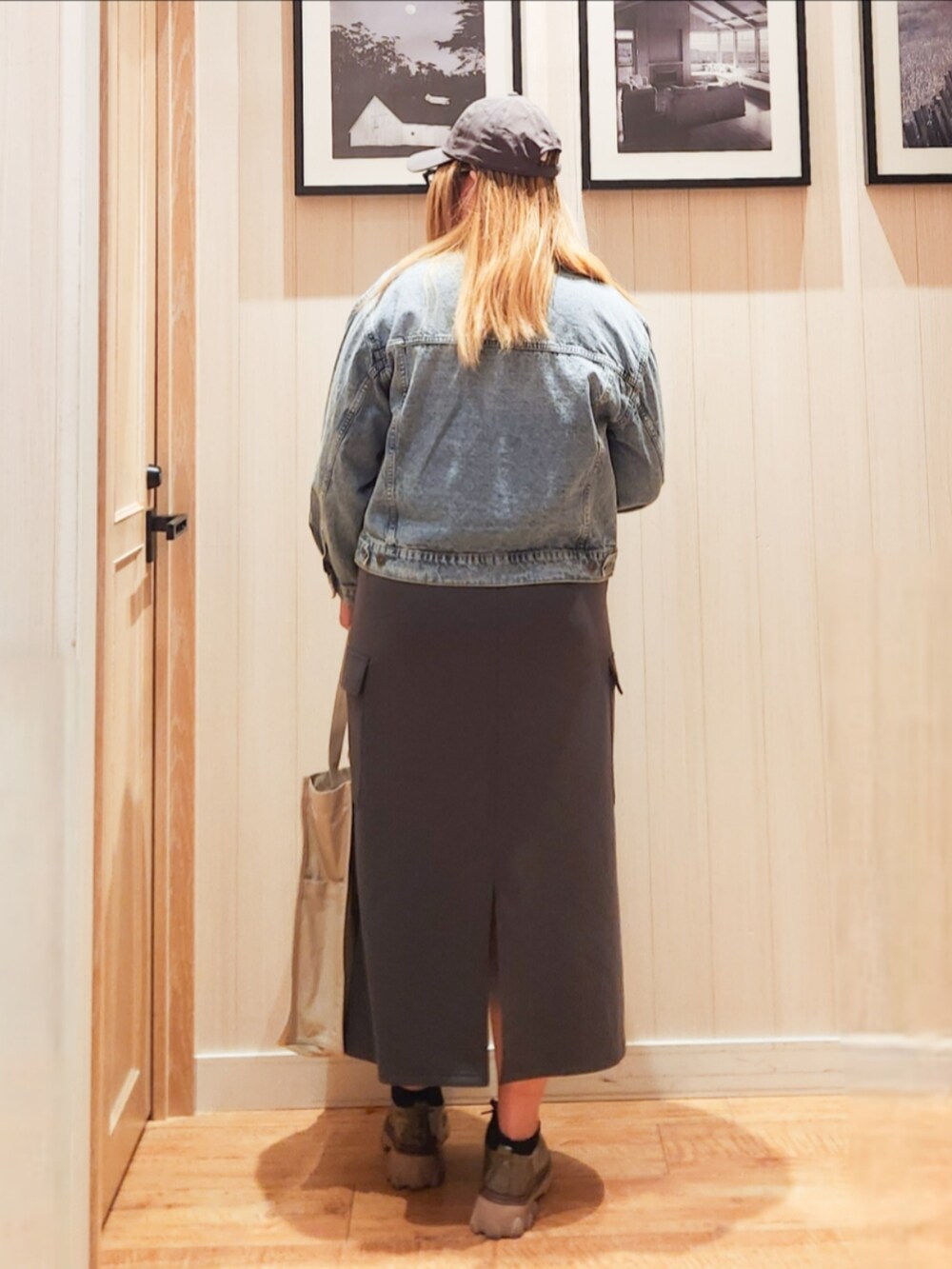 ブルー系のデニムジャケット、グレー系のニット/セーター、グレー系のスカートを着用したレディースの春コーディネートの3枚目の写真