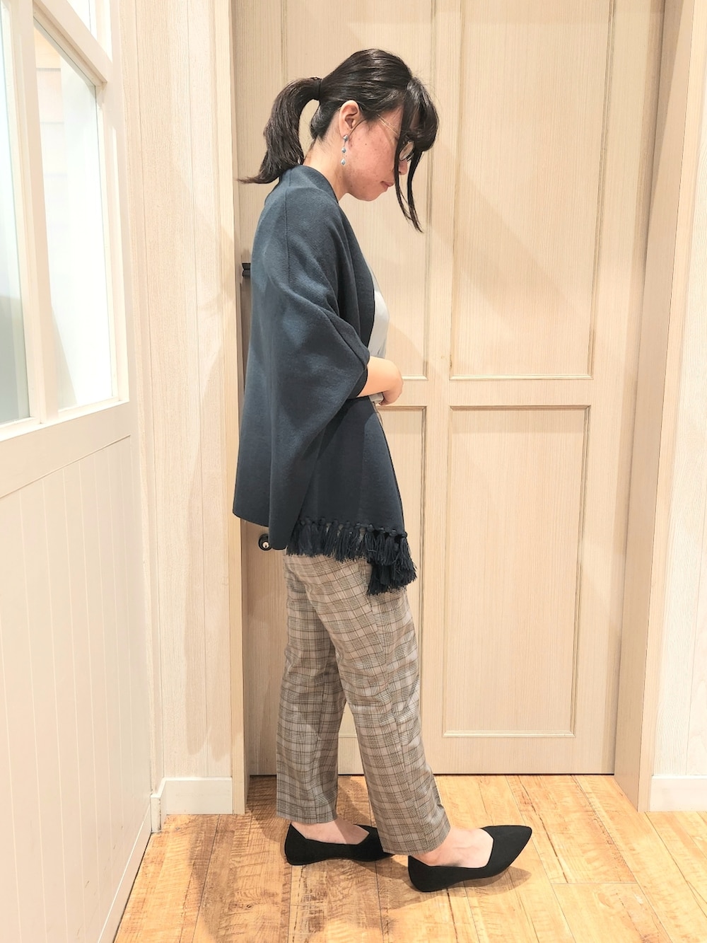 グリーン系のポンチョ、ブルー系のシャツ/ブラウス、グレー系のその他パンツを着用したレディースの秋コーディネートの2枚目の写真