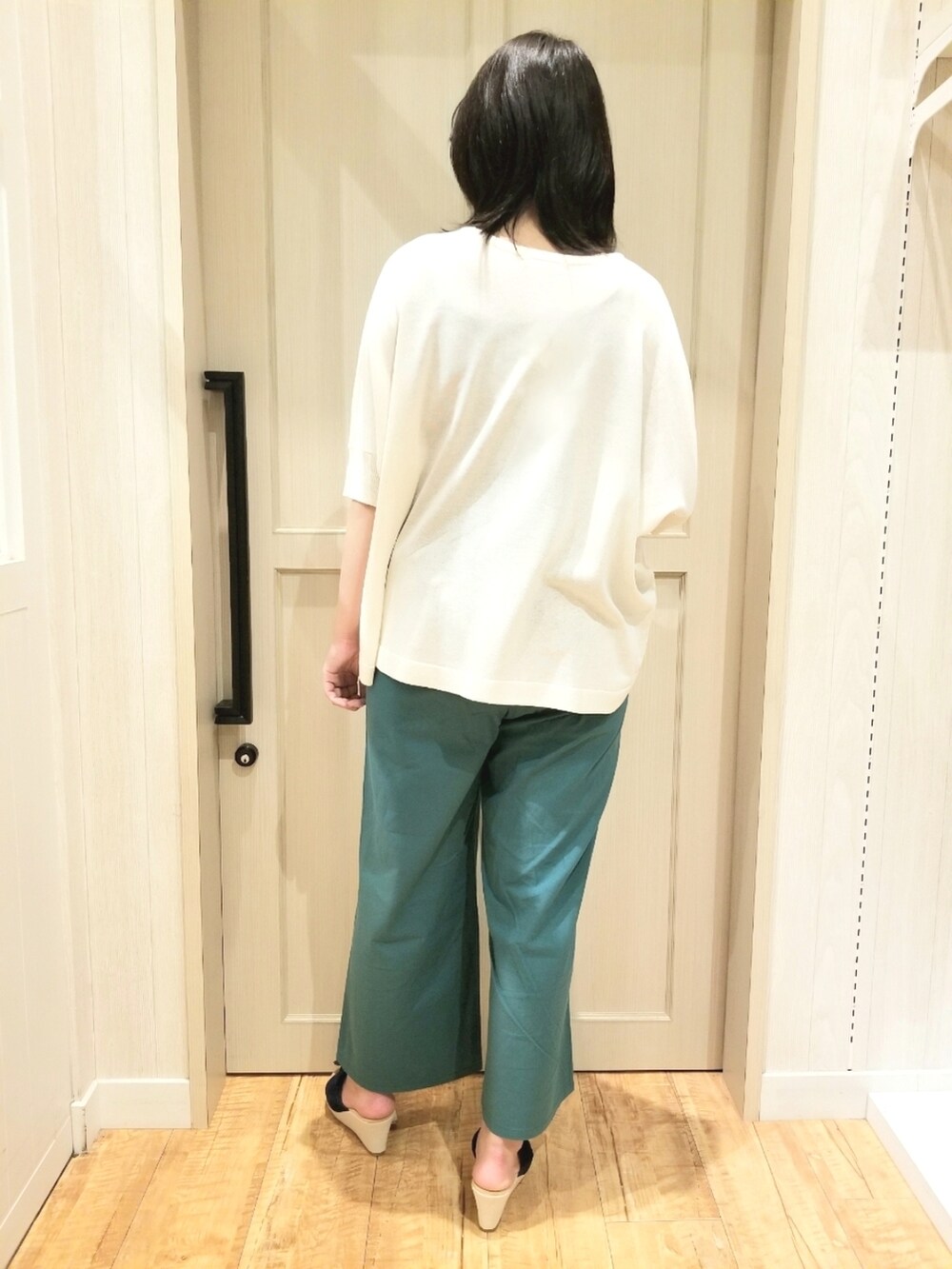 ホワイト系のニット/セーター、グリーン系のその他パンツ、ブルー系のサンダルを着用したレディースの春コーディネートの3枚目の写真