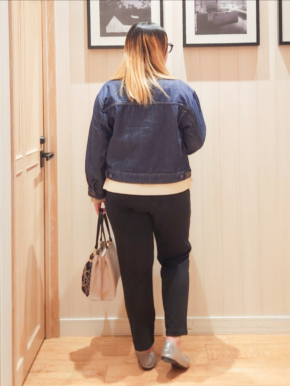 ブルー系のデニムジャケット、ホワイト系のニット/セーター、ブラック系のその他パンツを着用したレディースの春コーディネートの3枚目の写真