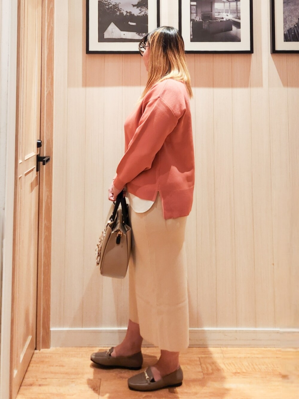 ピンク系のニット/セーター、ベージュ系のスカート、ベージュ系のトートバッグを着用したレディースの冬コーディネートの2枚目の写真