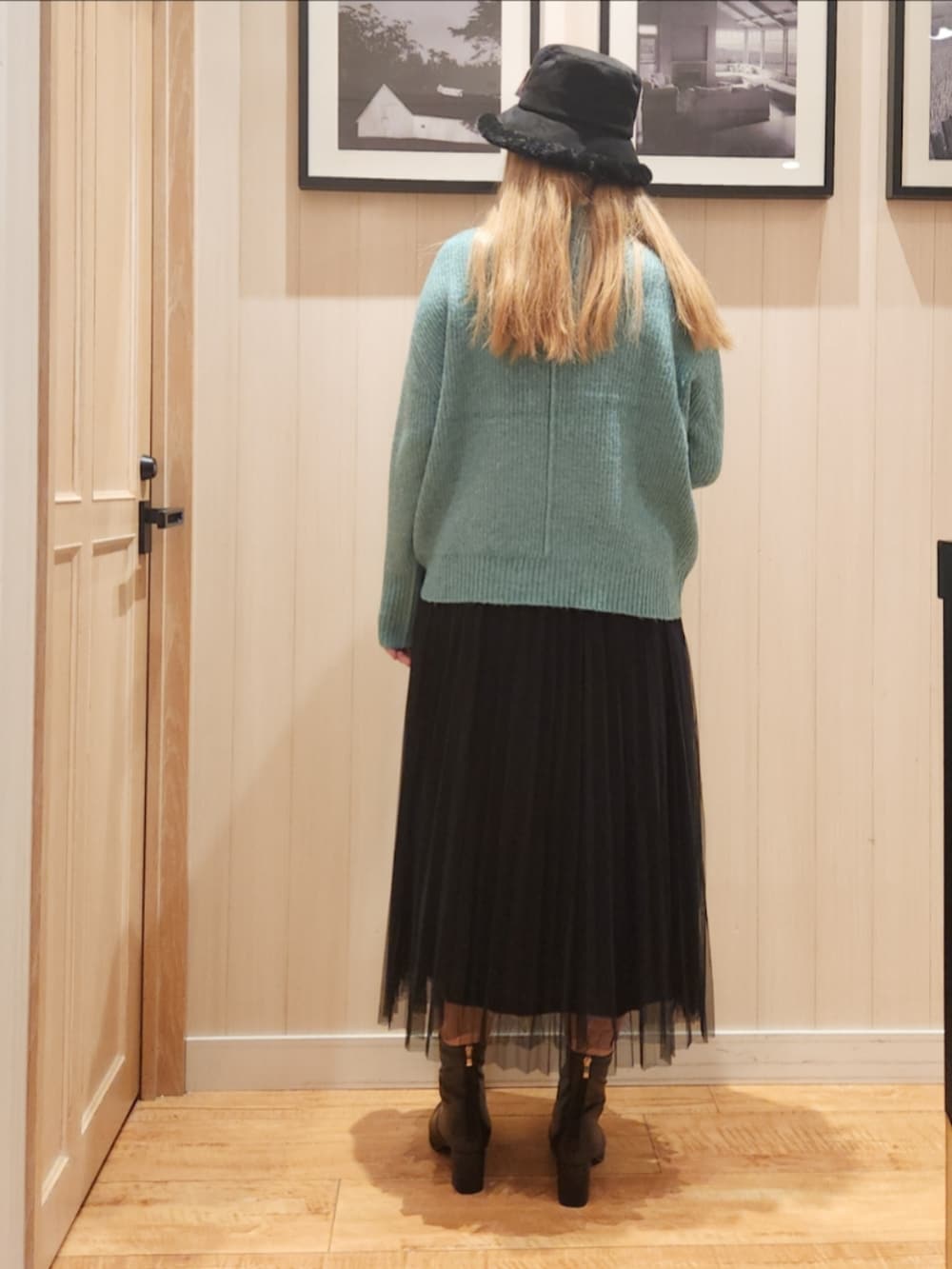 グリーン系のニット/セーター、ホワイト系のTシャツ/カットソー、ブラック系のスカートを着用したレディースの冬コーディネートの3枚目の写真