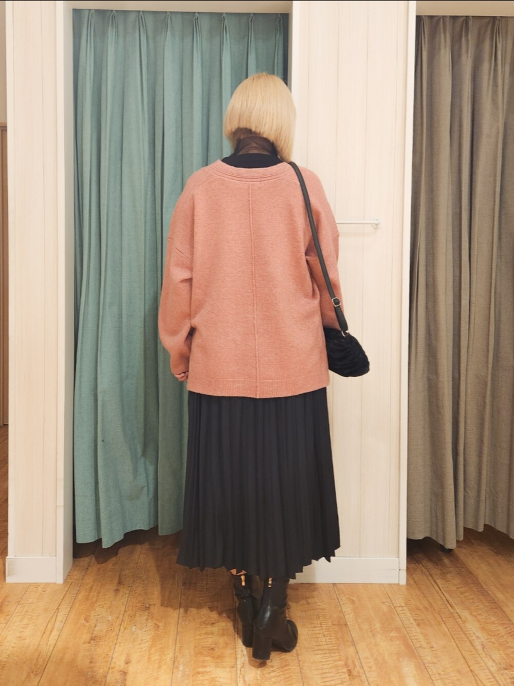 ピンク系のニット/セーター、ブラック系のTシャツ/カットソー、ブラック系のスカートを着用したレディースの冬コーディネートの3枚目の写真