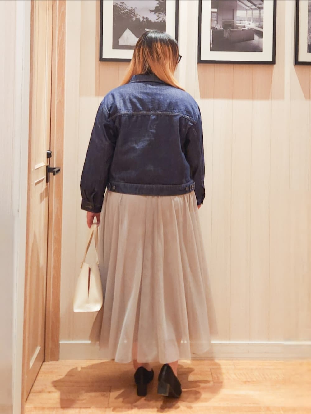 ブルー系のデニムジャケット、グレー系のニット/セーター、ベージュ系のスカートを着用したレディースの冬コーディネートの3枚目の写真