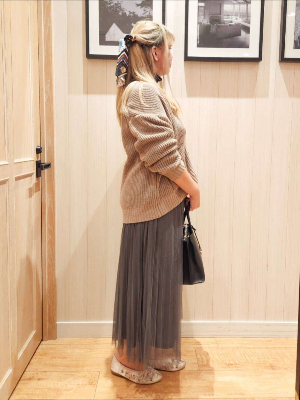 ベージュ系のカーディガン/ボレロ、ブラック系のニット/セーター、グレー系のスカートを着用したレディースの秋コーディネートの2枚目の写真