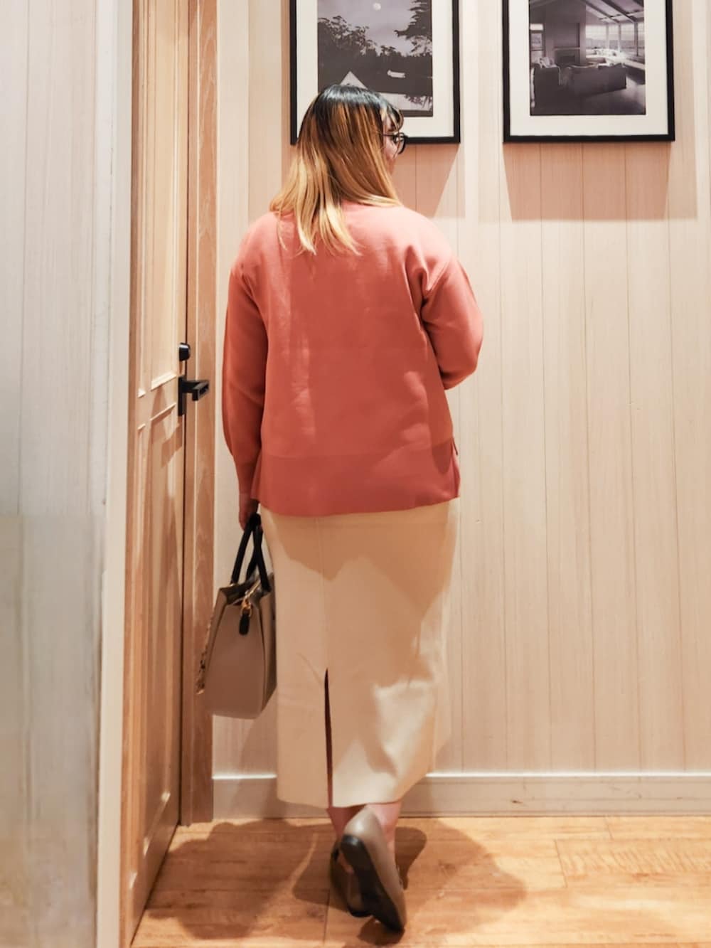 ピンク系のニット/セーター、ベージュ系のスカート、ベージュ系のトートバッグを着用したレディースの冬コーディネートの3枚目の写真