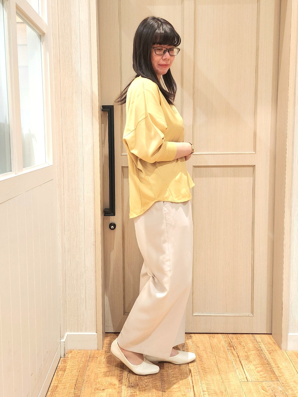 イエロー系のシャツ/ブラウス、ベージュ系のその他パンツ、ホワイト系のパンプスを着用したレディースの春コーディネートの2枚目の写真
