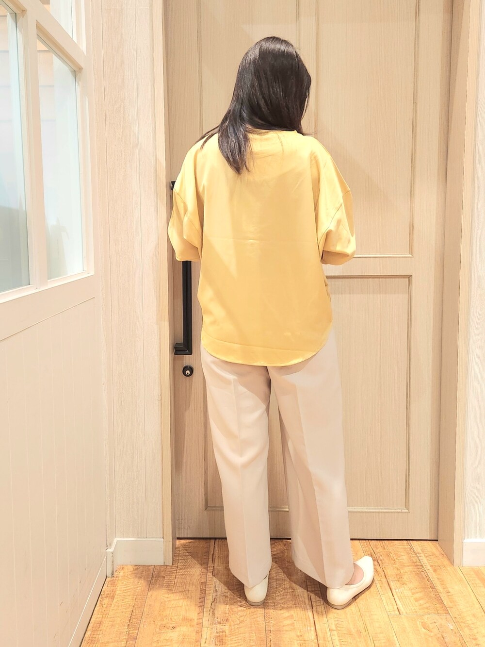 イエロー系のシャツ/ブラウス、ベージュ系のその他パンツ、ホワイト系のパンプスを着用したレディースの春コーディネートの3枚目の写真