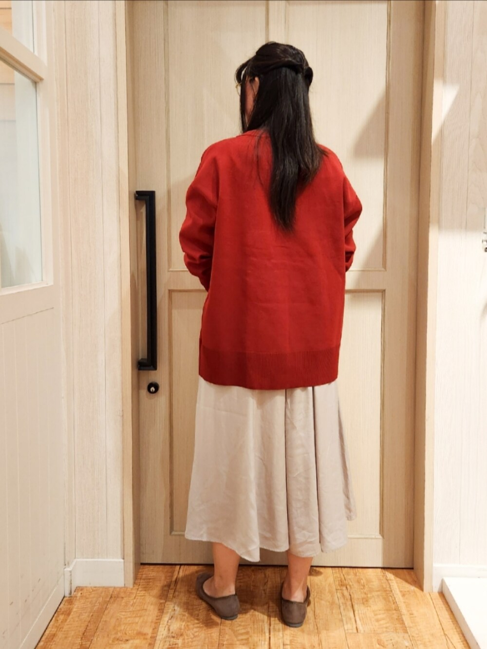 レッド系のカーディガン/ボレロ、ホワイト系のTシャツ/カットソー、ブラック系のショルダーバッグを着用したレディースの秋コーディネートの3枚目の写真