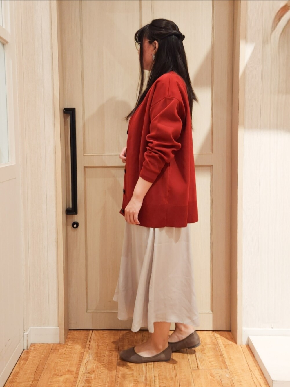 レッド系のカーディガン/ボレロ、ホワイト系のTシャツ/カットソー、ブラック系のショルダーバッグを着用したレディースの秋コーディネートの2枚目の写真