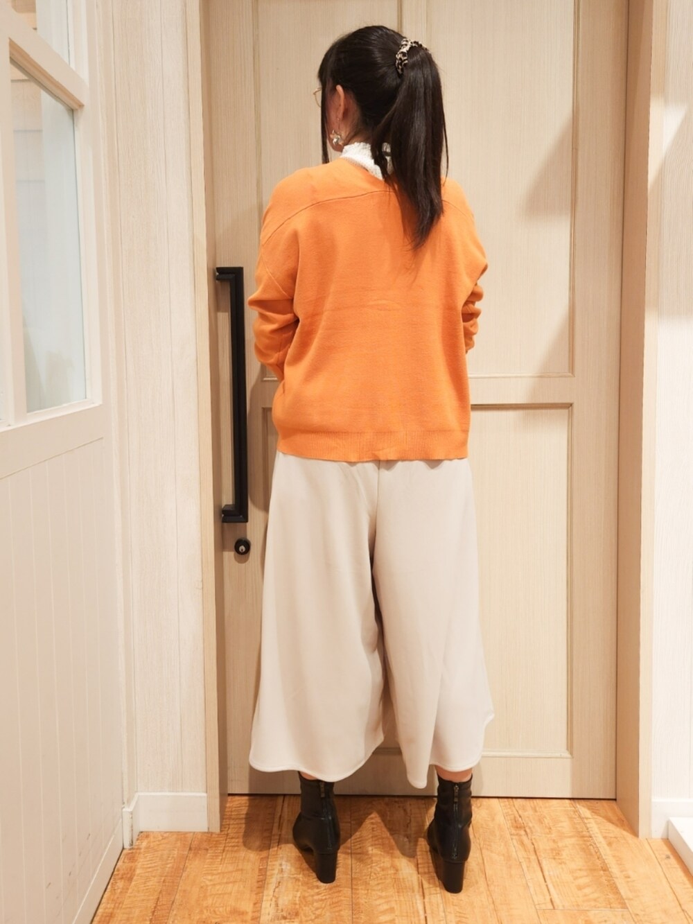 オレンジ系のカーディガン/ボレロ、ホワイト系のシャツ/ブラウス、ベージュ系のその他パンツを着用したレディースの秋コーディネートの3枚目の写真