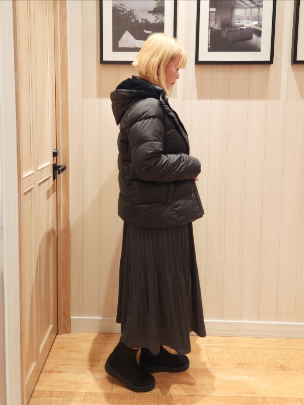 ブラック系のダウンジャケット/コート、グレー系のTシャツ/カットソー、グレー系のスカートを着用したレディースの冬コーディネートの2枚目の写真