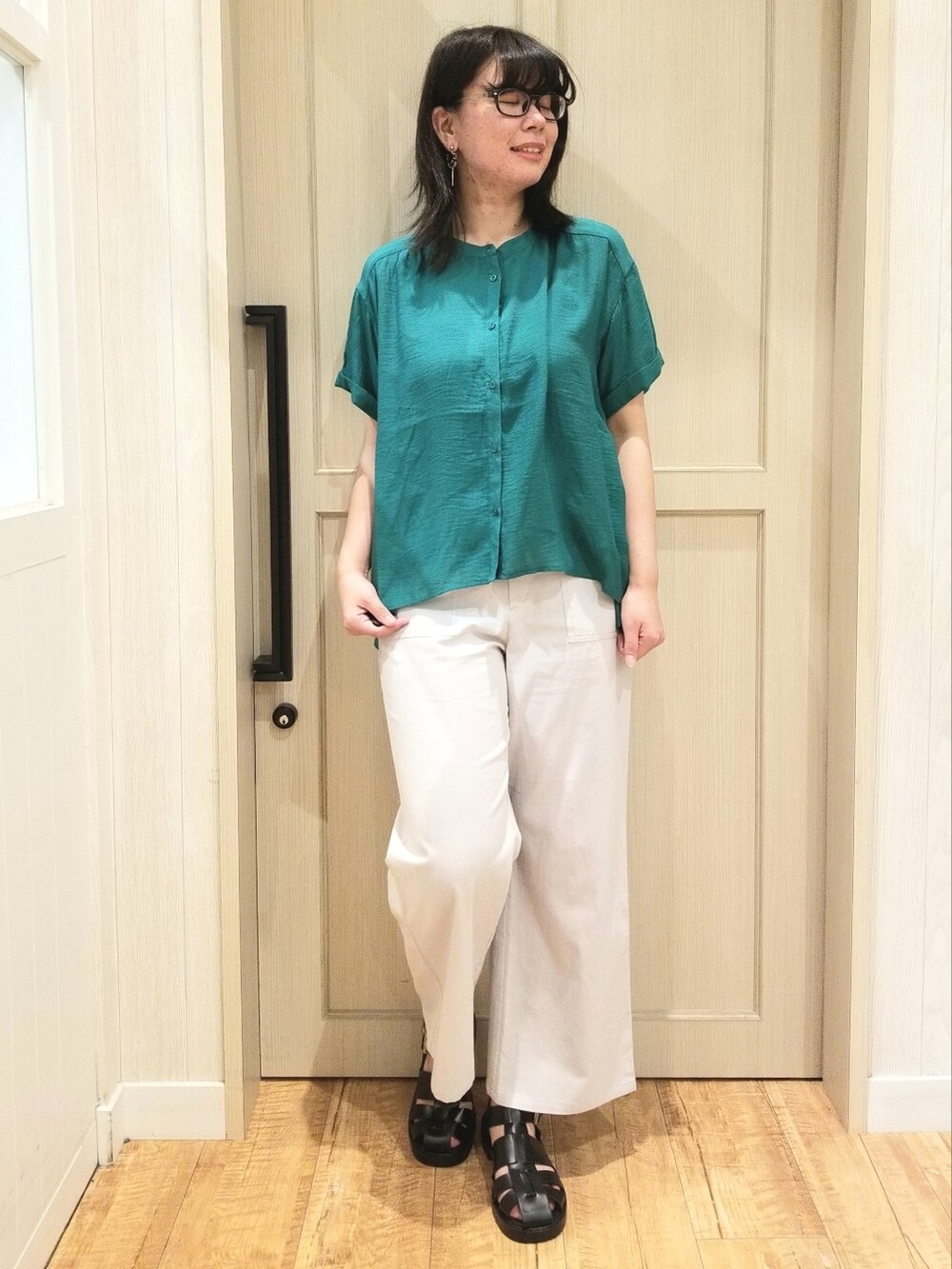 グリーン系のシャツ/ブラウス、グレー系のその他パンツ、ブラック系のサンダルを着用したレディースの春コーディネートの2枚目の写真