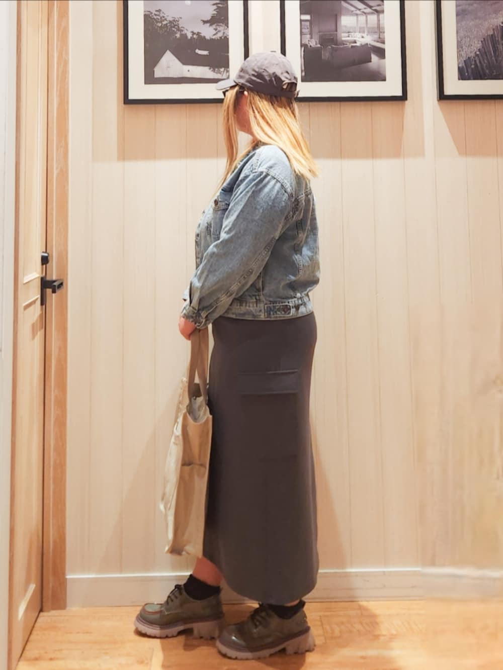 ブルー系のデニムジャケット、グレー系のニット/セーター、グレー系のスカートを着用したレディースの春コーディネートの2枚目の写真