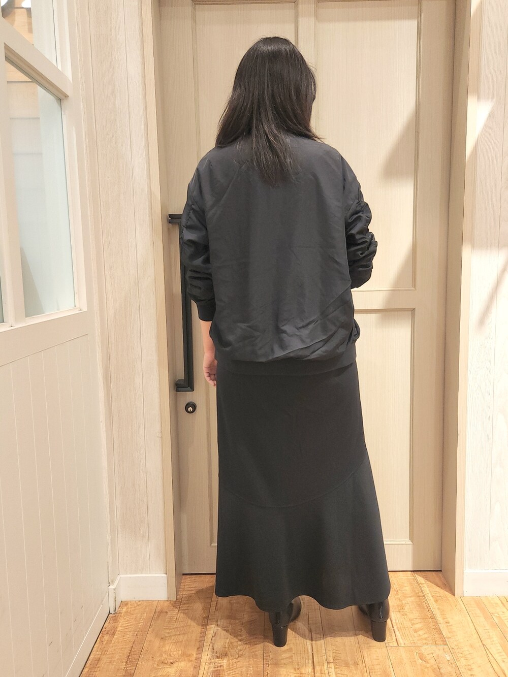 ホワイト系のシャツ/ブラウス、ブラック系のブルゾン、ブラック系のブーツを着用したレディースの秋コーディネートの3枚目の写真
