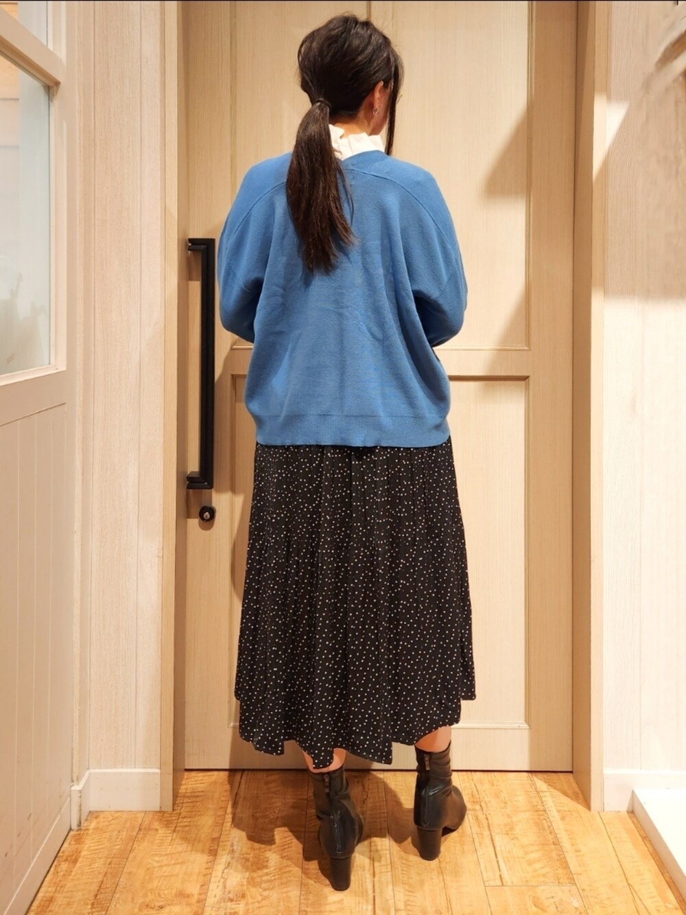 ブルー系のカーディガン/ボレロ、ホワイト系のシャツ/ブラウス、ブラック系のスカートを着用したレディースの冬コーディネートの2枚目の写真