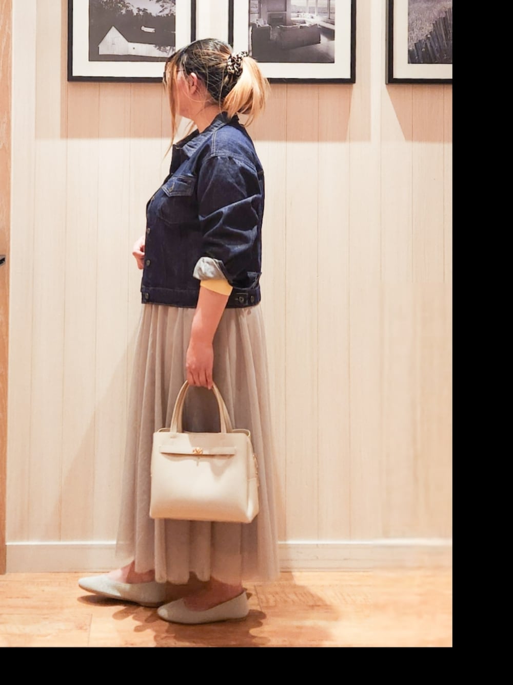 ブルー系のデニムジャケット、イエロー系のニット/セーター、ベージュ系のスカートを着用したレディースの春コーディネートの2枚目の写真