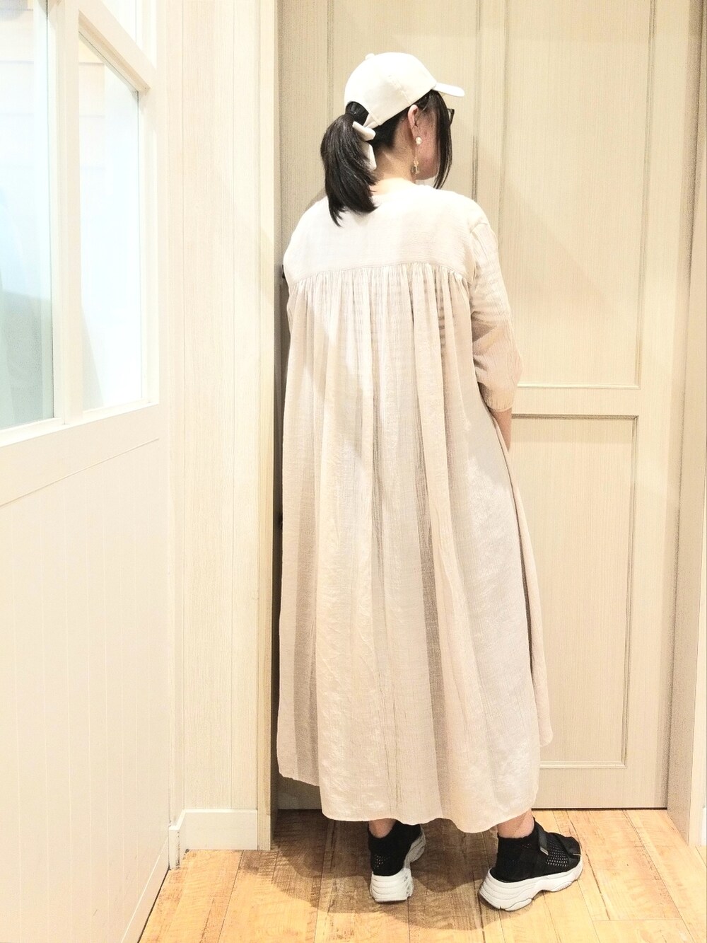 ブラック系のTシャツ/カットソー、ベージュ系のワンピース、ブルー系のスカートを着用したレディースの夏コーディネートの3枚目の写真