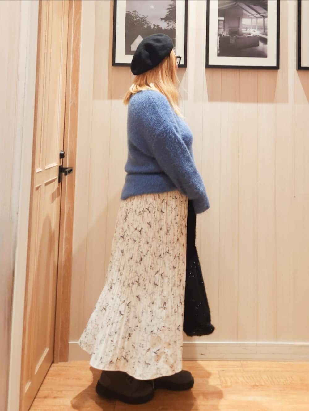 ブルー系のニット/セーター、ベージュ系のスカート、ブラック系のトートバッグを着用したレディースの冬コーディネートの2枚目の写真