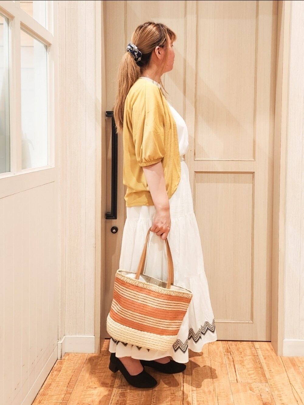 イエロー系のカーディガン/ボレロ、ホワイト系のTシャツ/カットソー、ホワイト系のスカートを着用したレディースの夏コーディネートの2枚目の写真