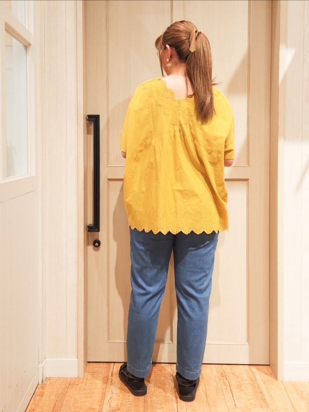イエロー系のシャツ/ブラウス、ブルー系のデニムパンツ、ブラック系のサンダルを着用したレディースの夏コーディネートの3枚目の写真