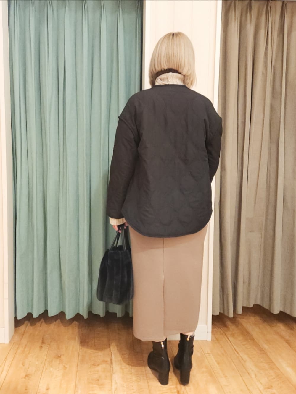 ブラック系のその他アウター、ベージュ系のニット/セーター、ブラウン系のスカートを着用したレディースの冬コーディネートの3枚目の写真