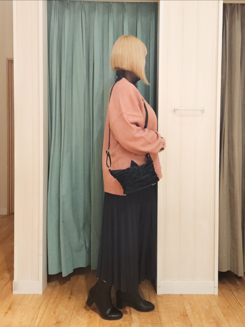 ピンク系のニット/セーター、ブラック系のTシャツ/カットソー、ブラック系のスカートを着用したレディースの冬コーディネートの2枚目の写真