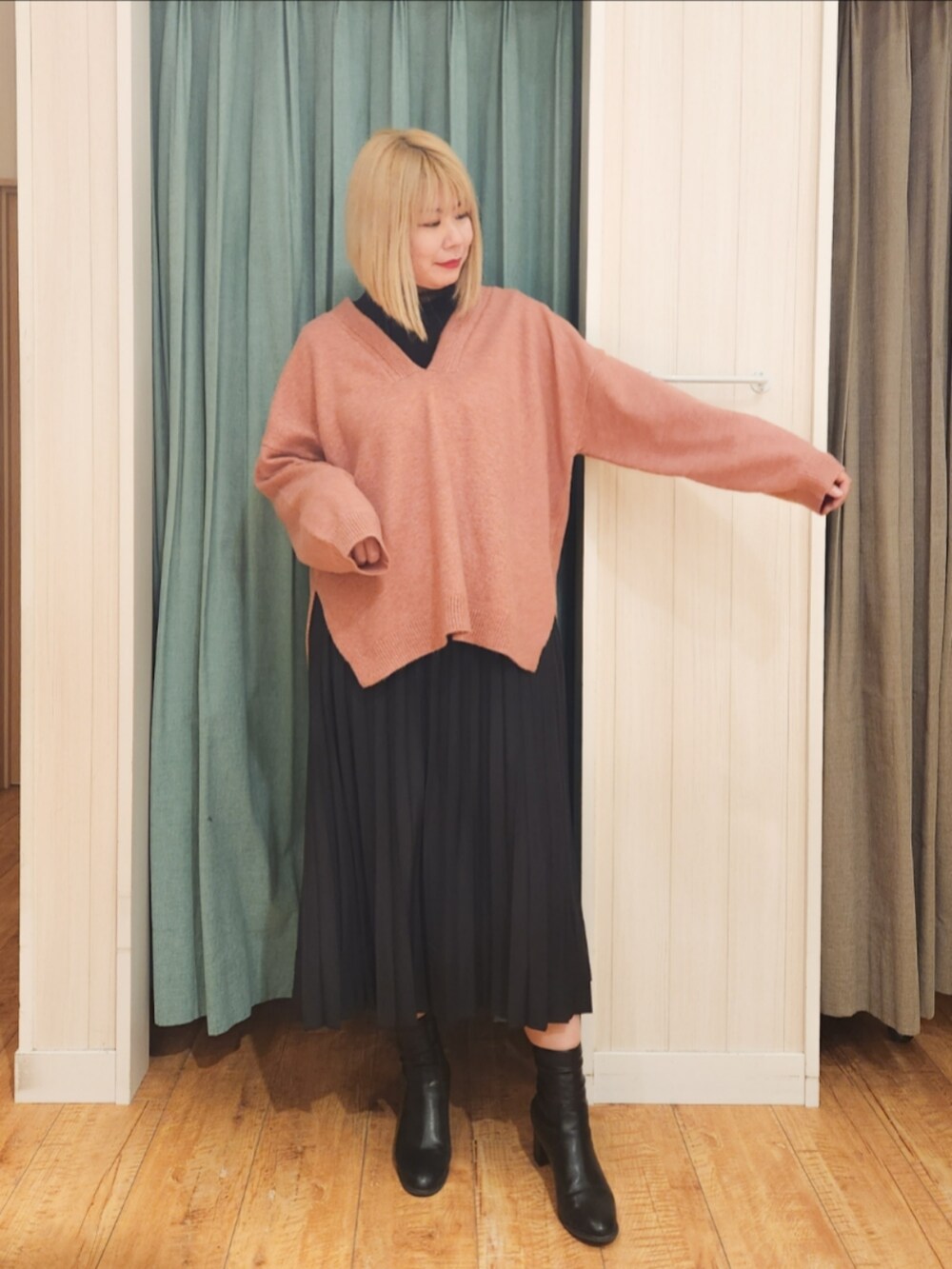 ピンク系のニット/セーター、ブラック系のTシャツ/カットソー、ブラック系のスカートを着用したレディースの冬コーディネートの4枚目の写真