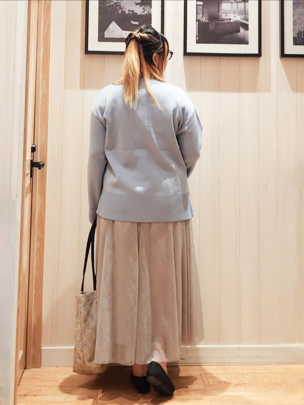 ブルー系のニット/セーター、ベージュ系のスカート、ブラック系のパンプスを着用したレディースの春コーディネートの3枚目の写真