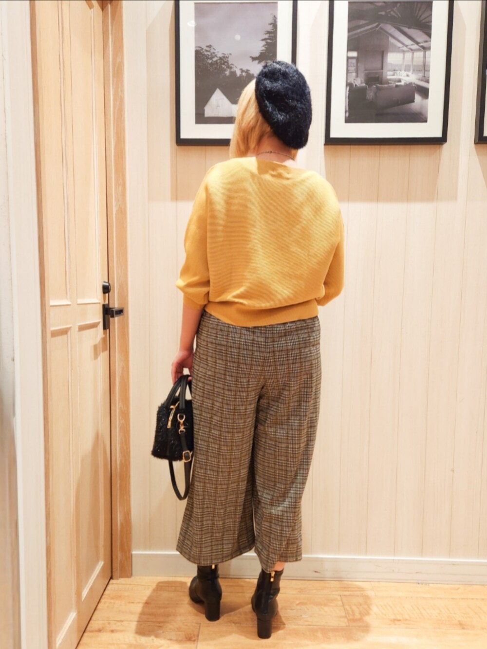 イエロー系のニット/セーター、ベージュ系のその他パンツ、ブラック系のブーツを着用したレディースの冬コーディネートの3枚目の写真
