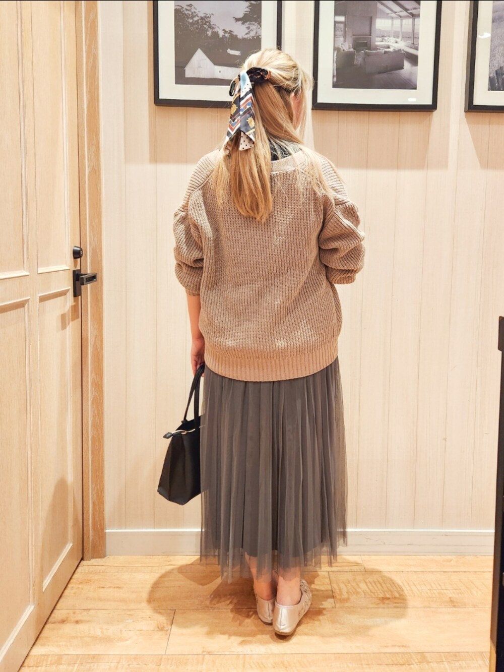 ベージュ系のカーディガン/ボレロ、ブラック系のニット/セーター、グレー系のスカートを着用したレディースの秋コーディネートの3枚目の写真