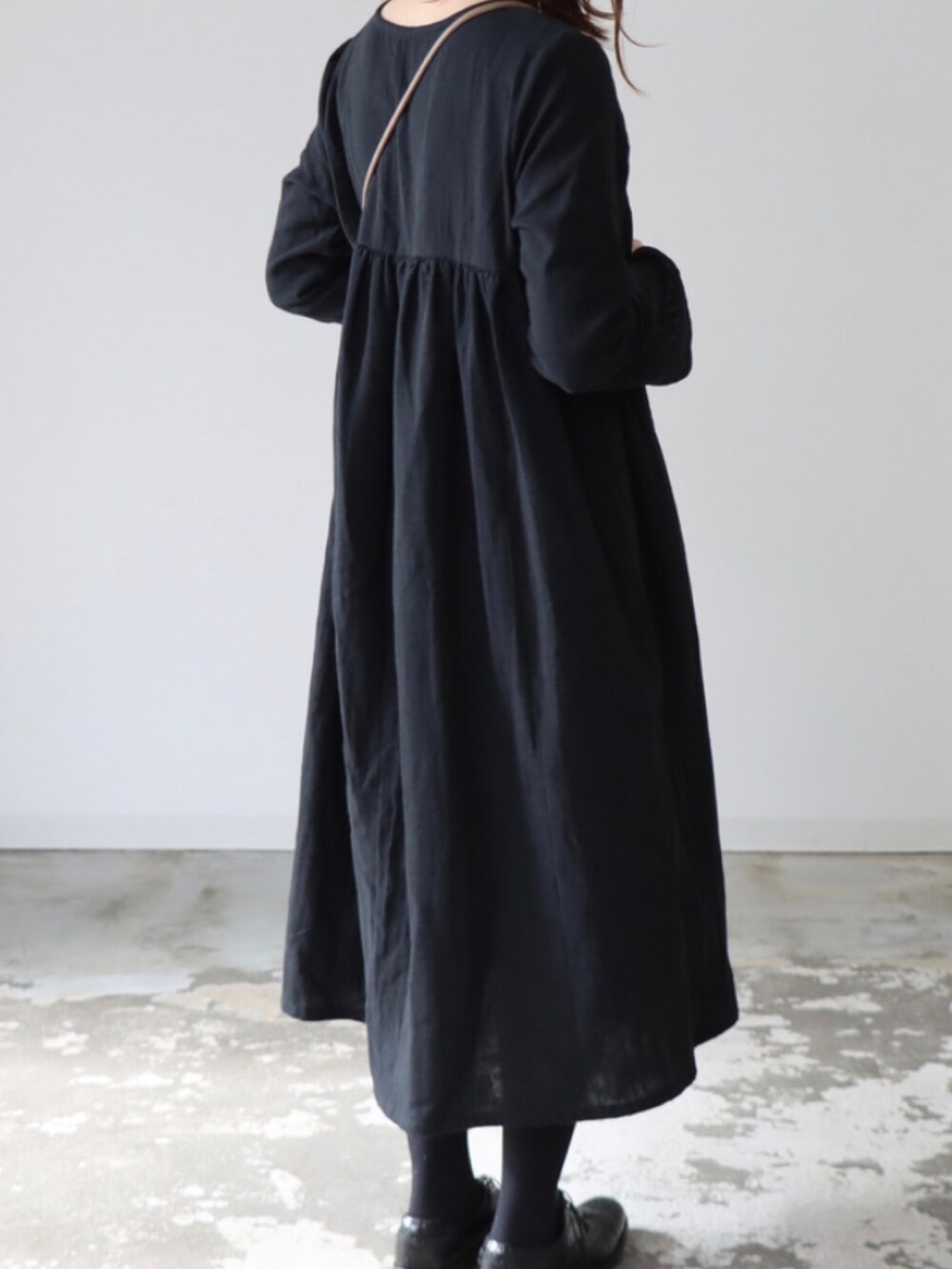 ブラック系のドレスシューズ、グレー系のバッグ、ブラック系のワンピース/ドレスを着用したレディースの冬コーディネートの2枚目の写真