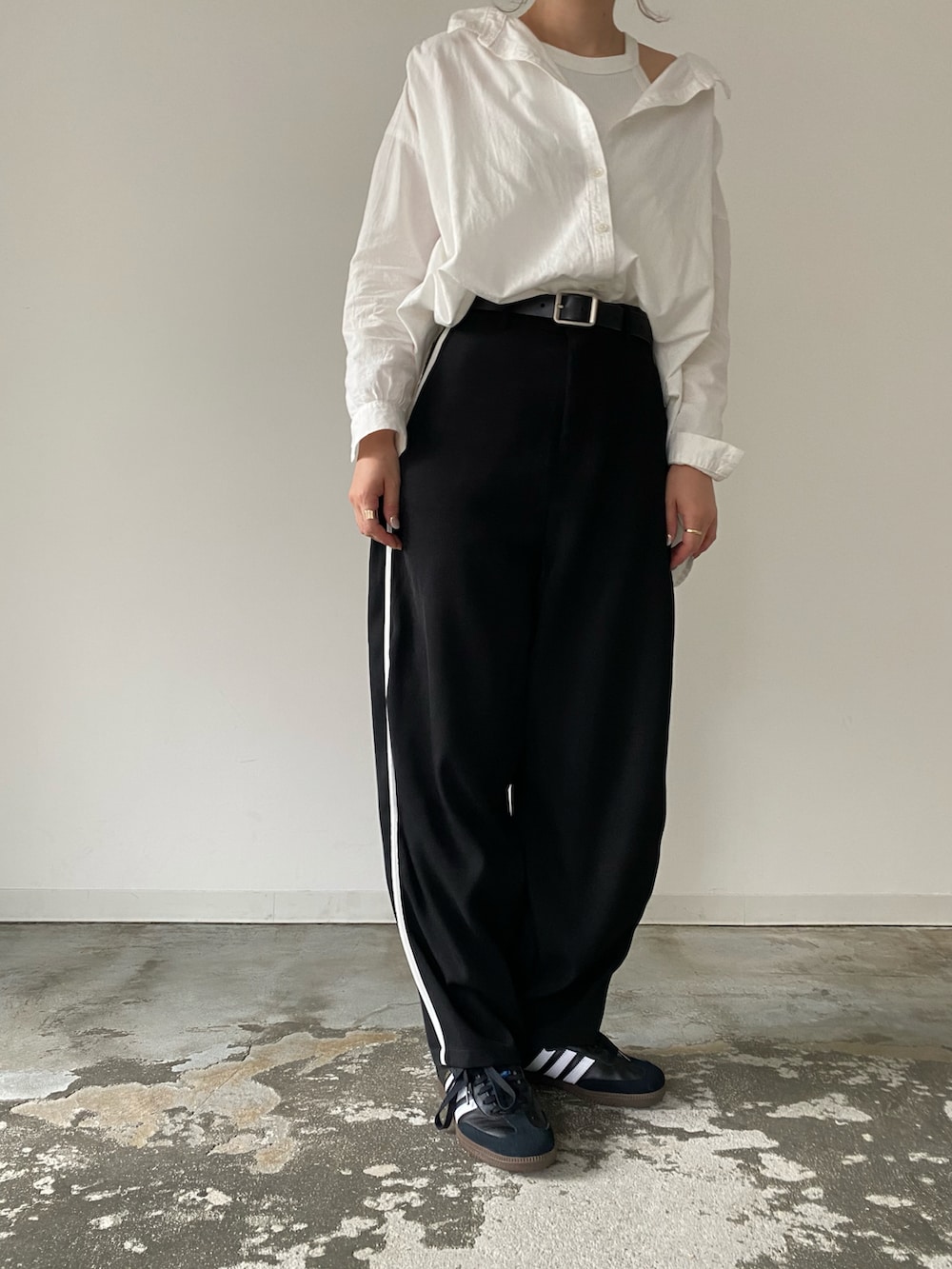 ブラック系のその他パンツ、ブラック系のスニーカー、ホワイト系のシャツ/ブラウスを着用したレディースの夏コーディネートの2枚目の写真