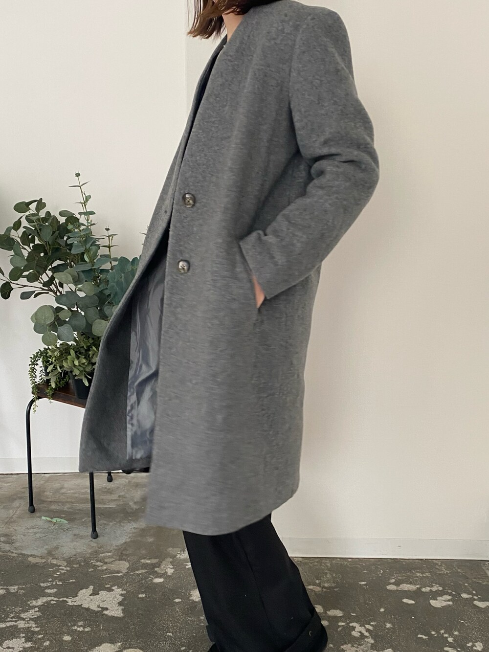 ブラック系のカーディガン/ボレロ、ブラック系のハンドバッグ、グレー系のノーカラーコートを着用したレディースの冬コーディネートの2枚目の写真