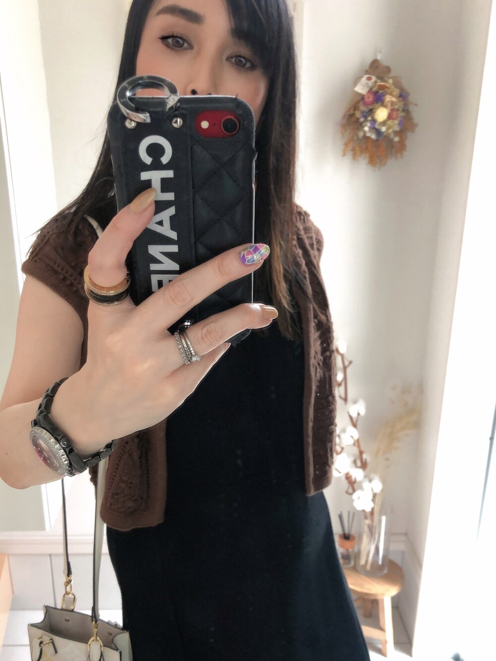 ブラウン系のベスト、ベージュ系のショルダーバッグ、ブラック系のワンピースを着用したレディースの夏コーディネートの2枚目の写真