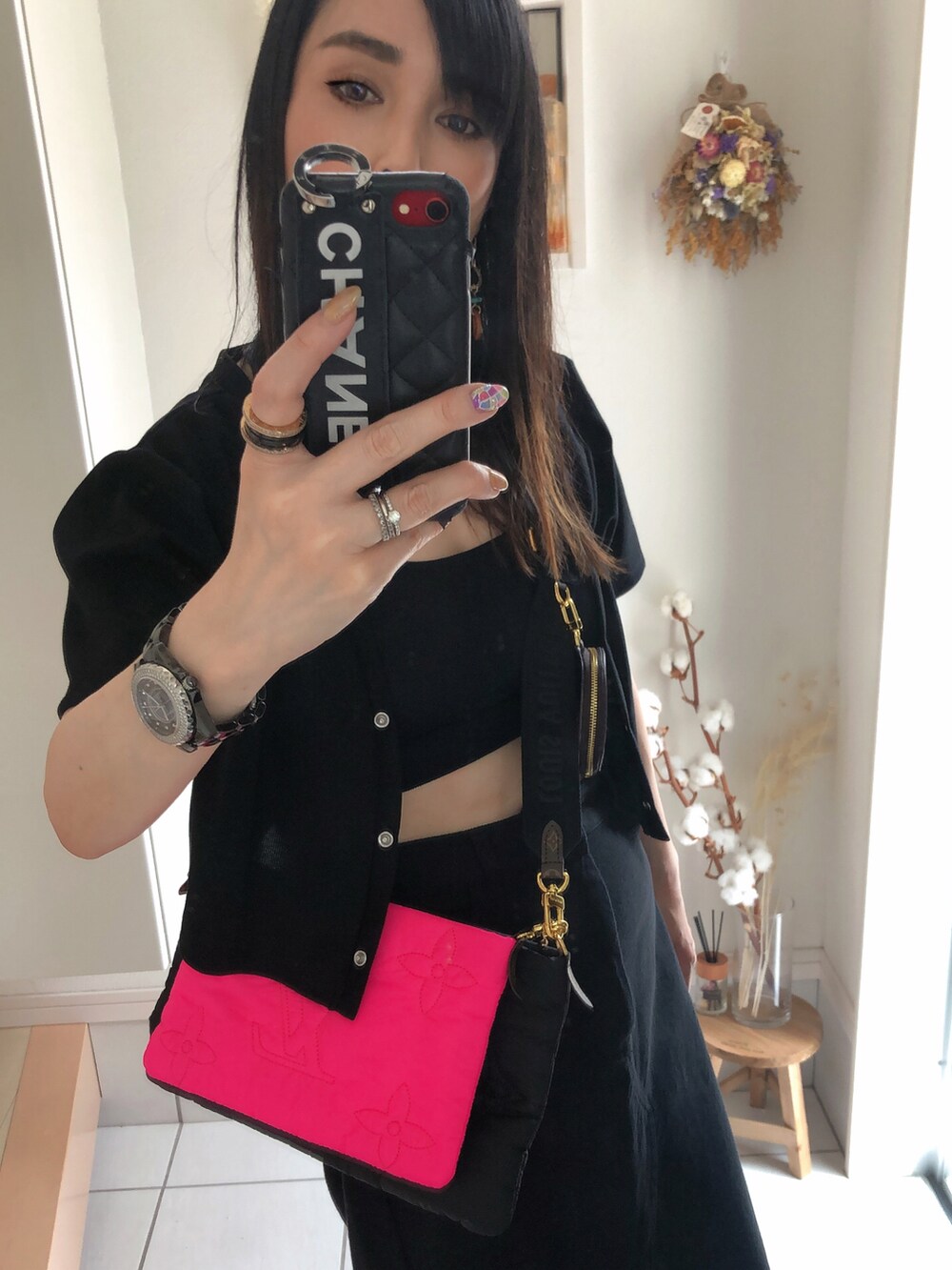 ブラック系のワンピース、ブラック系のデニムスカート、ピンク系のバッグを着用したレディースの夏コーディネートの2枚目の写真