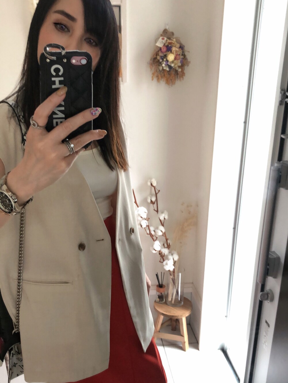 ホワイト系のタンクトップ、ブラック系のショルダーバッグ、ホワイト系のベストを着用したレディースの夏コーディネートの2枚目の写真