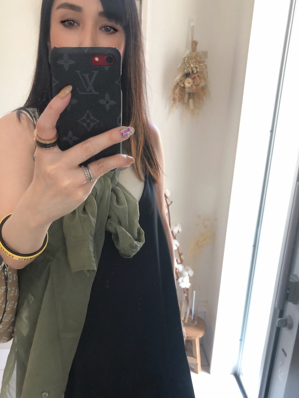 グリーン系のトートバッグ、ホワイト系のタンクトップ、ブラック系のサンダルを着用したレディースの夏コーディネートの2枚目の写真