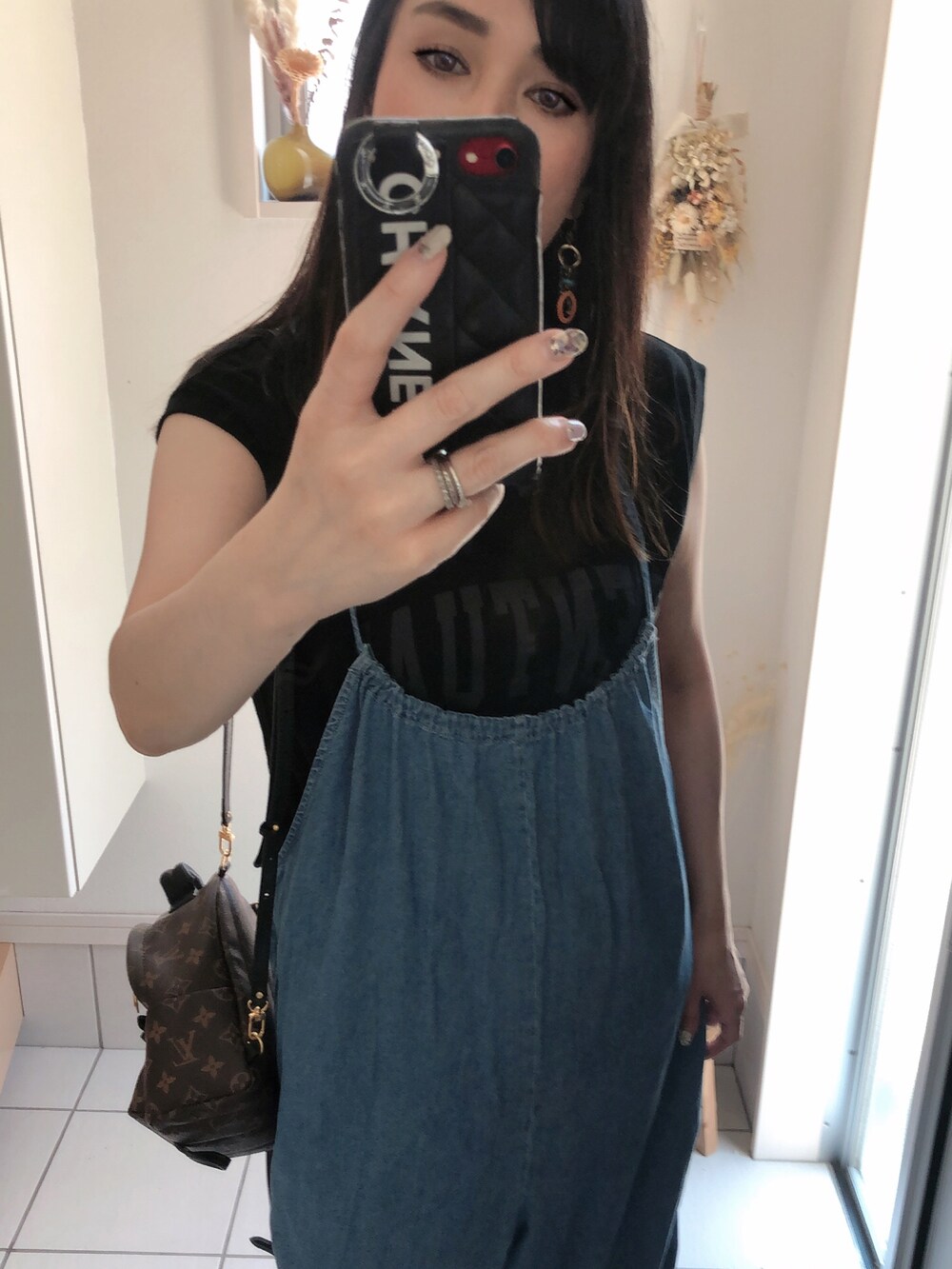 ブラック系のTシャツ/カットソー、ブルー系のオールインワン・サロペット、ブラウン系のバックパック/リュックを着用したレディースの夏コーディネートの2枚目の写真