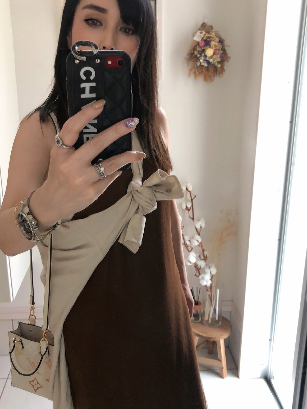 ホワイト系のタンクトップ、ホワイト系のシャツ/ブラウス、ベージュ系のショルダーバッグを着用したレディースの夏コーディネートの2枚目の写真