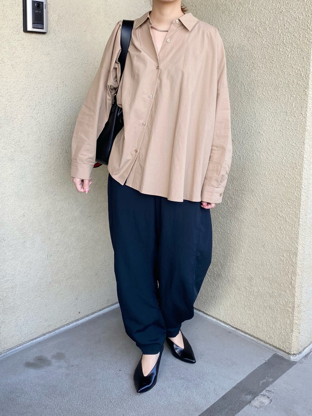 ブラック系のパンツ、ベージュ系のシャツ/ブラウス、ブラック系のパンプスを着用したレディースの秋コーディネートの2枚目の写真