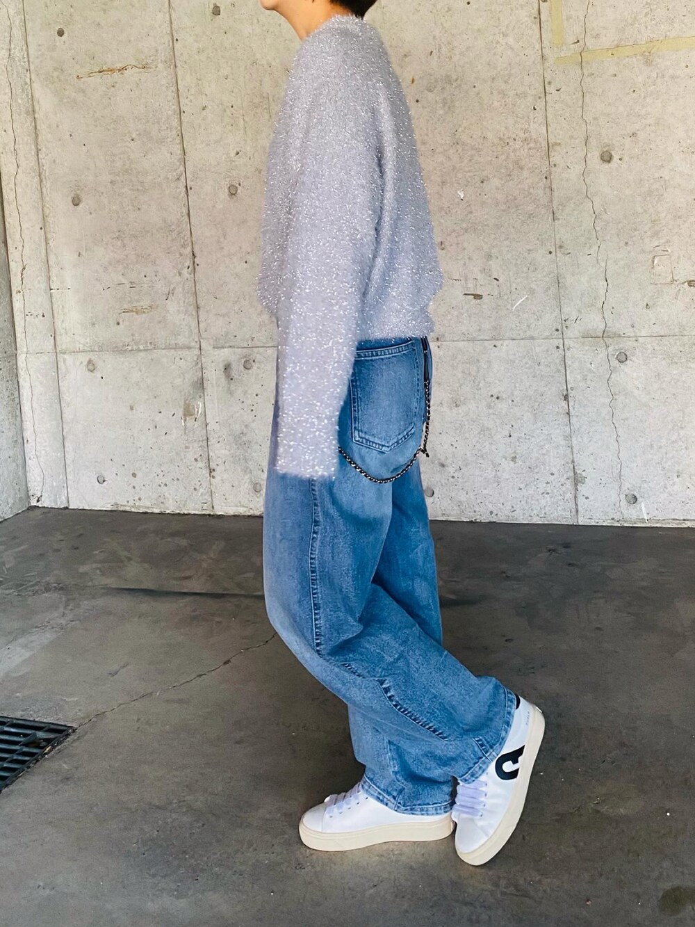 ホワイト系のスニーカー、ブルー系のデニムパンツ、グレー系のニット/セーターを着用したレディースの冬コーディネートの4枚目の写真