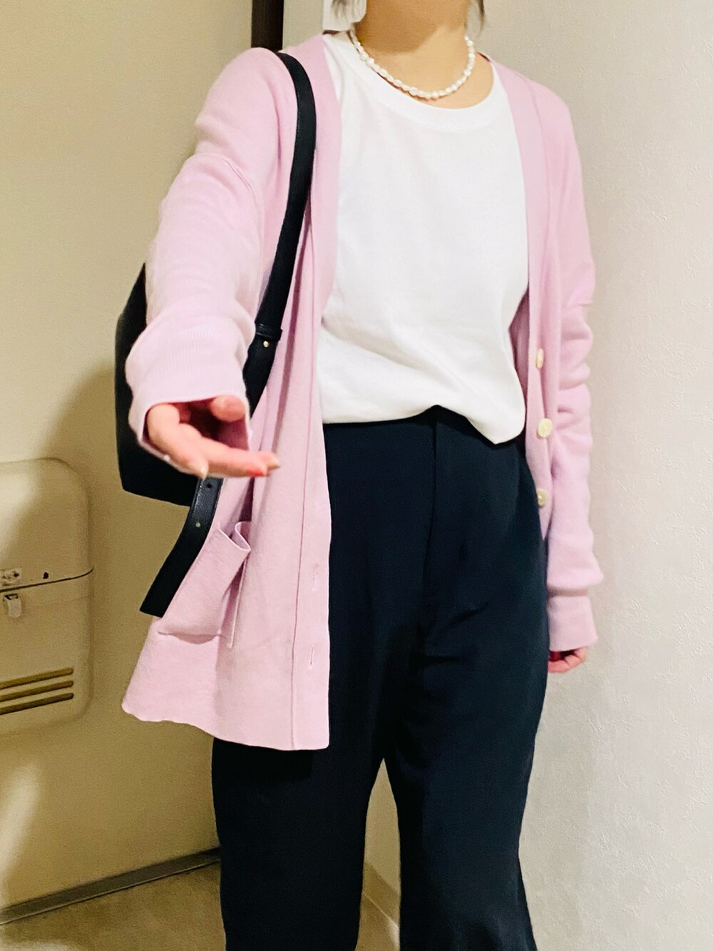 ピンク系のカーディガン/ボレロ、ブラック系のパンプス、ブラック系のパンツを着用したレディースの秋コーディネートの4枚目の写真