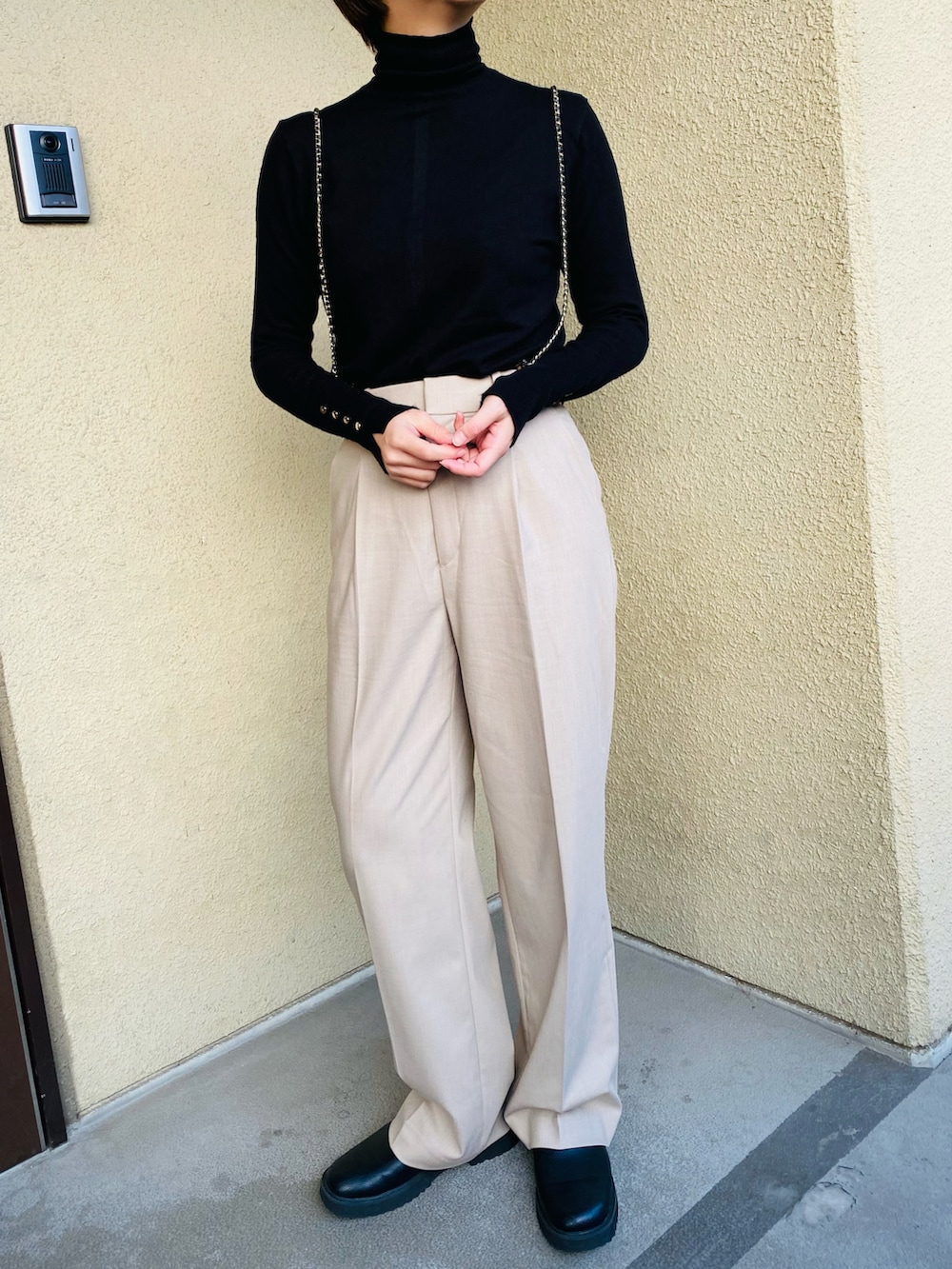 ブラック系のニット/セーター、ベージュ系のパンツ、ブラック系のブルゾンを着用したレディースの冬コーディネートの2枚目の写真