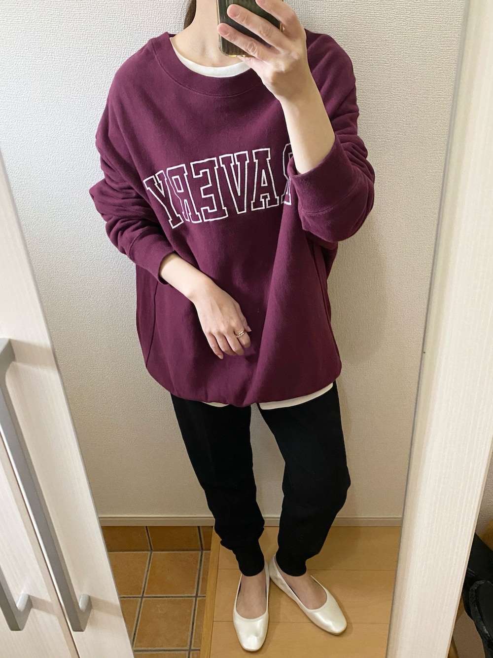 レッド系のスウェット、ホワイト系のTシャツ/カットソー、ブラック系のその他パンツを着用したレディースの冬コーディネートの2枚目の写真