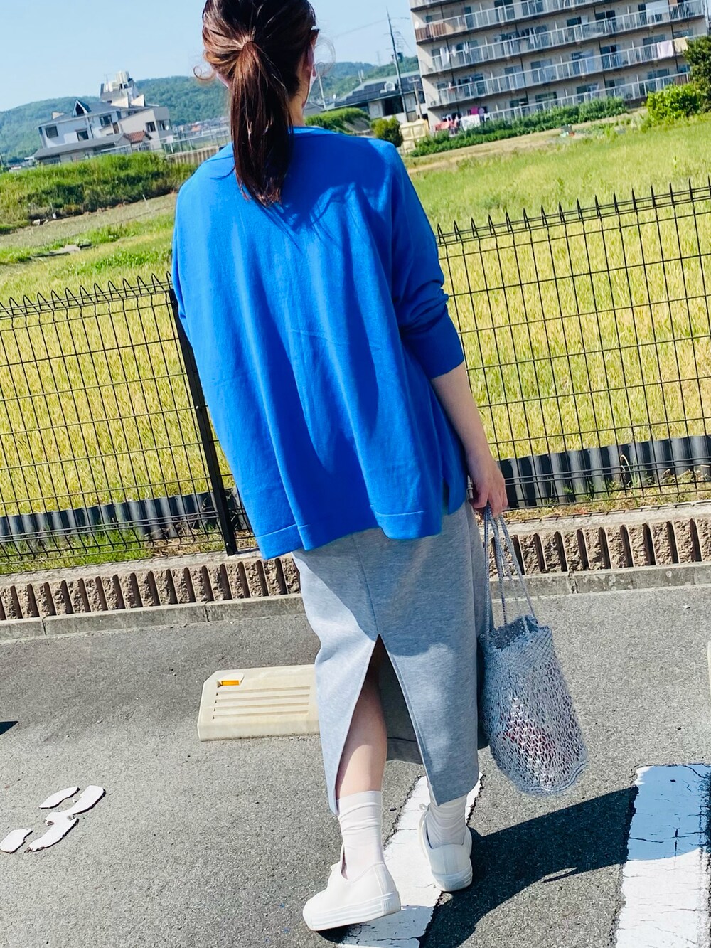 ホワイト系のTシャツ/カットソー、グレー系のスカート、その他のバッグを着用したレディースの春コーディネートの2枚目の写真