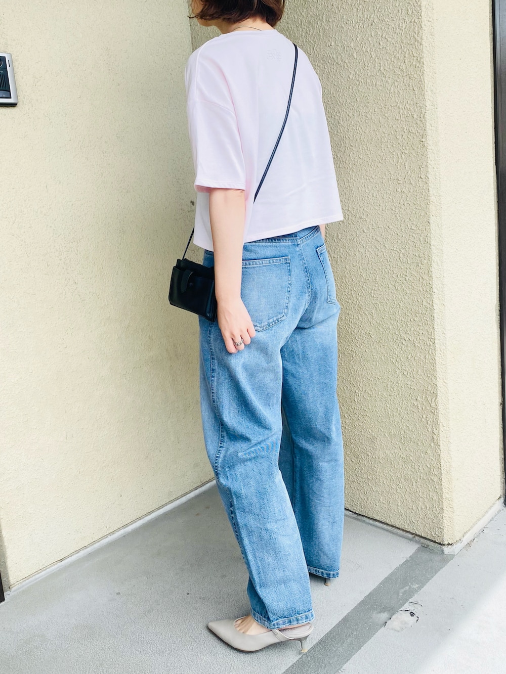 ブルー系のデニムパンツ、ピンク系のTシャツ/カットソー、グレー系のパンプスを着用したレディースの夏コーディネートの4枚目の写真