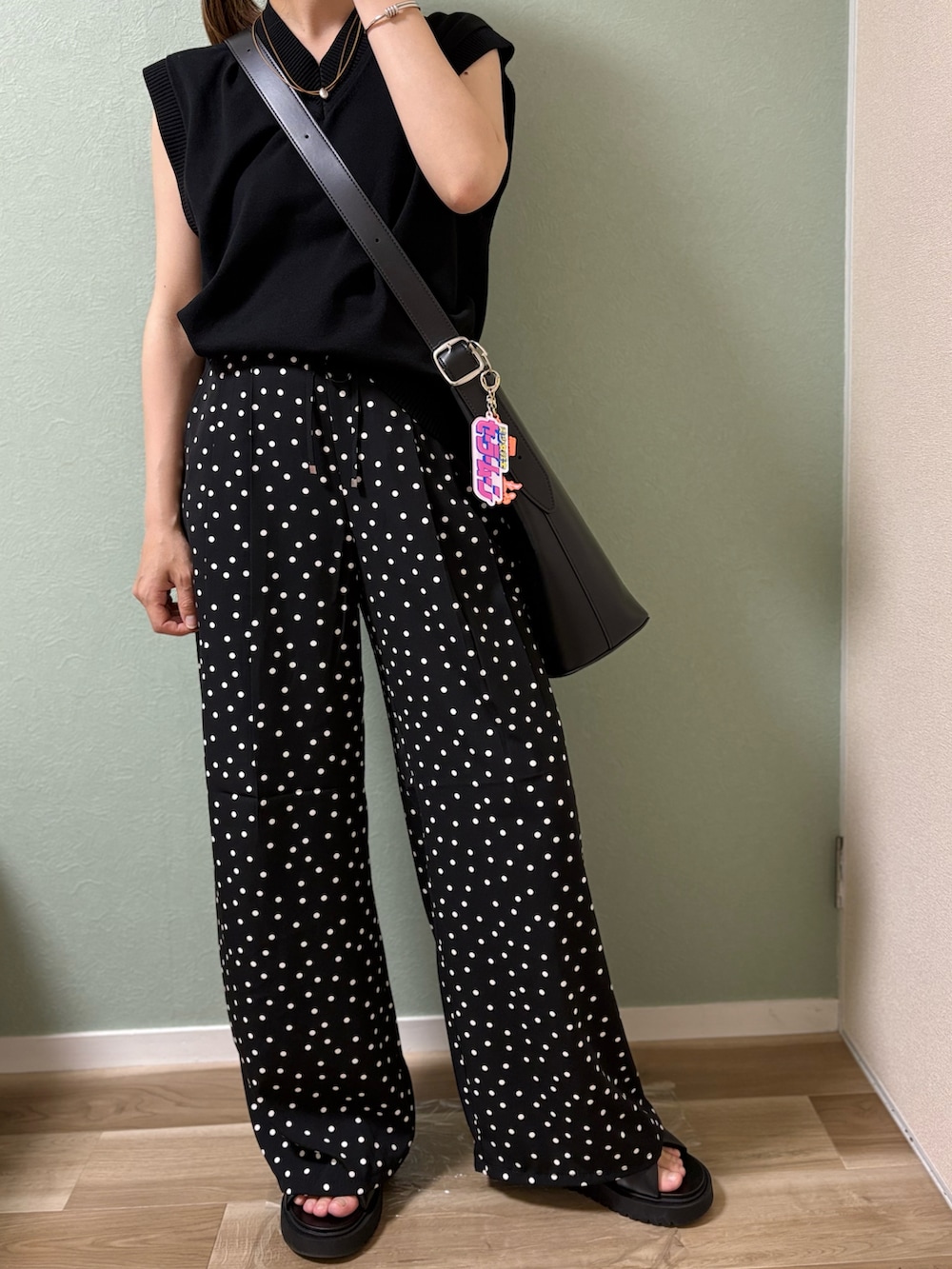 ブラック系のパンツ、ブラック系のベスト、ブラック系のサンダルを着用したレディースの夏コーディネートの3枚目の写真